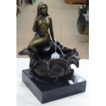 A reproduction bronze depicting a nude girl seated