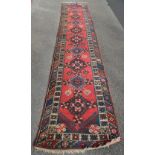 A Persian design blue and red ground wool runner.