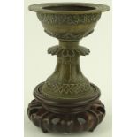 A Chinese relief cast bronze chalice, on carved ha