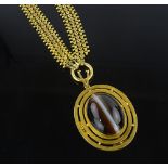 An unmarked gold banded agate set pendant on ornat