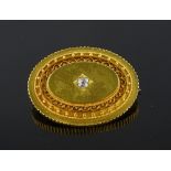 A Victorian unmarked gold filigree oval brooch wit
