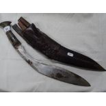 A Kukri knife with horn handle and leather scabbar