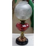 A Victorian oil lamp with Cranberry glass font.