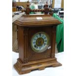 An oak cased mantel clock with painted dial.