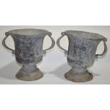 A pair of heavy lead garden urns with relief cast