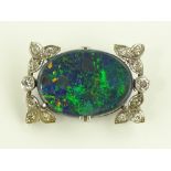 A stylish black opal sliver and diamond set brooch