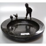 A polished marble dish surmounted by bronze patina