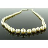 A string of graduated cultured pearls with diamond