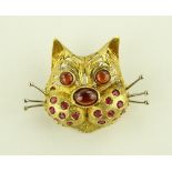 An 18ct gold ruby and garnet set cat brooch, textu