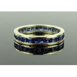 An unmarked white metal sapphire eternity ring, se