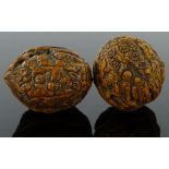 2 Oriental relief carved walnuts.