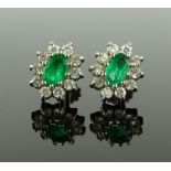 A pair of emerald and diamond set cluster earrings