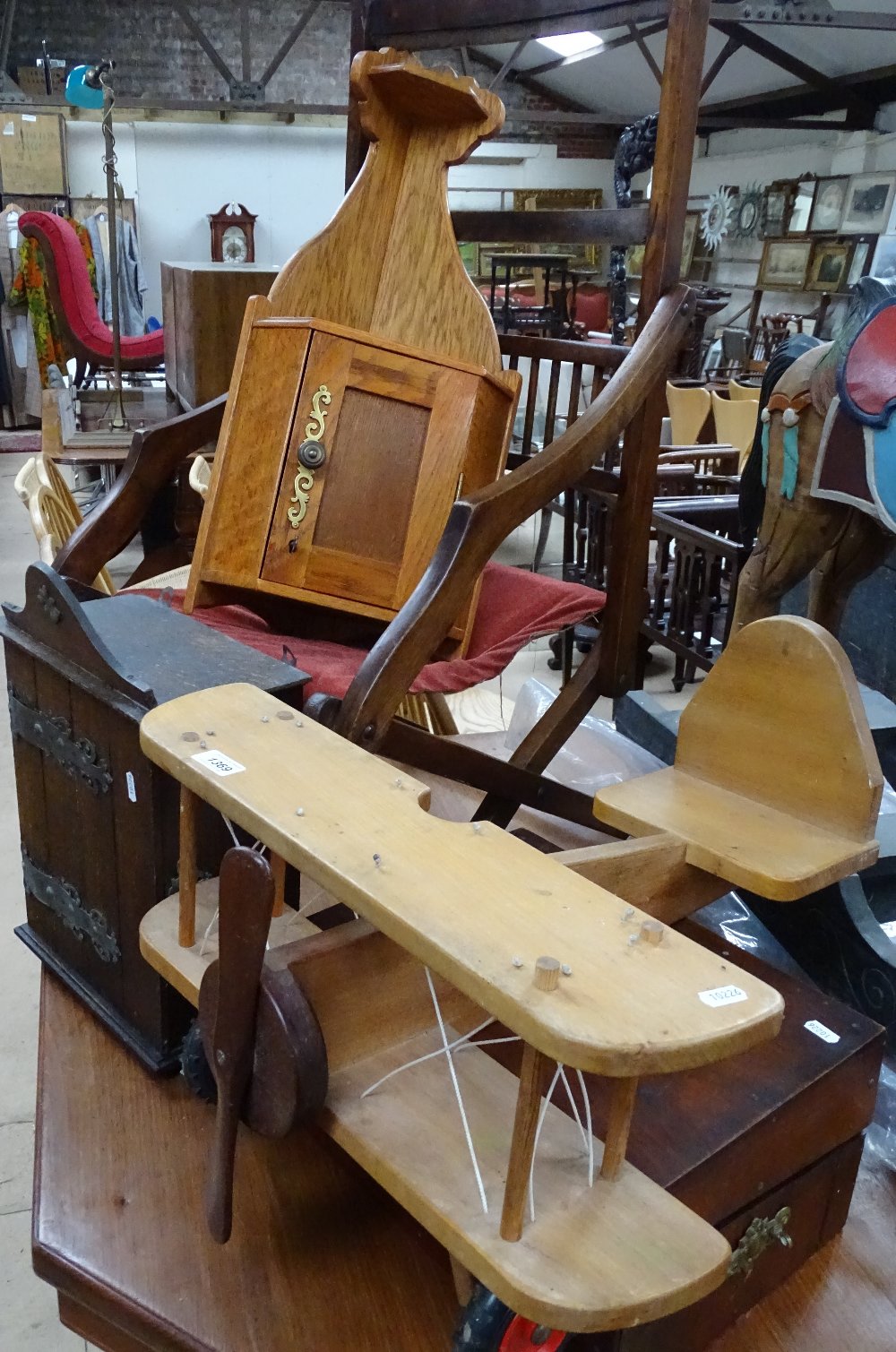A child's wooden aeroplane, a folding chair, a cor