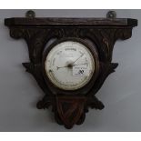 A Victorian aneroid barometer in carved wood wall-