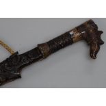 An antique Dayak head hunting sword with carved horn handle and carved