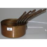 A graduated set of 5 copper saucepans with iron ha