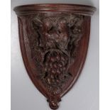 An Antique carved oak clock bracket, with grapes a