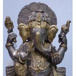 An Indian bronze figure of Ganesh, on carved wood