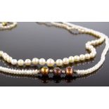 A graduated single string pearl necklace with unma