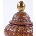 An Islamic gilded terracotta vase and cover, heigh