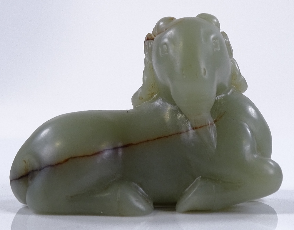 A Chinese green jade carving of a reclining goat,