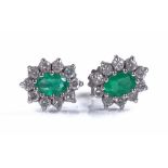 A pair of 18ct white gold emerald and diamond clus
