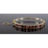 A Victorian 9ct gold graduated garnet hinged bangl