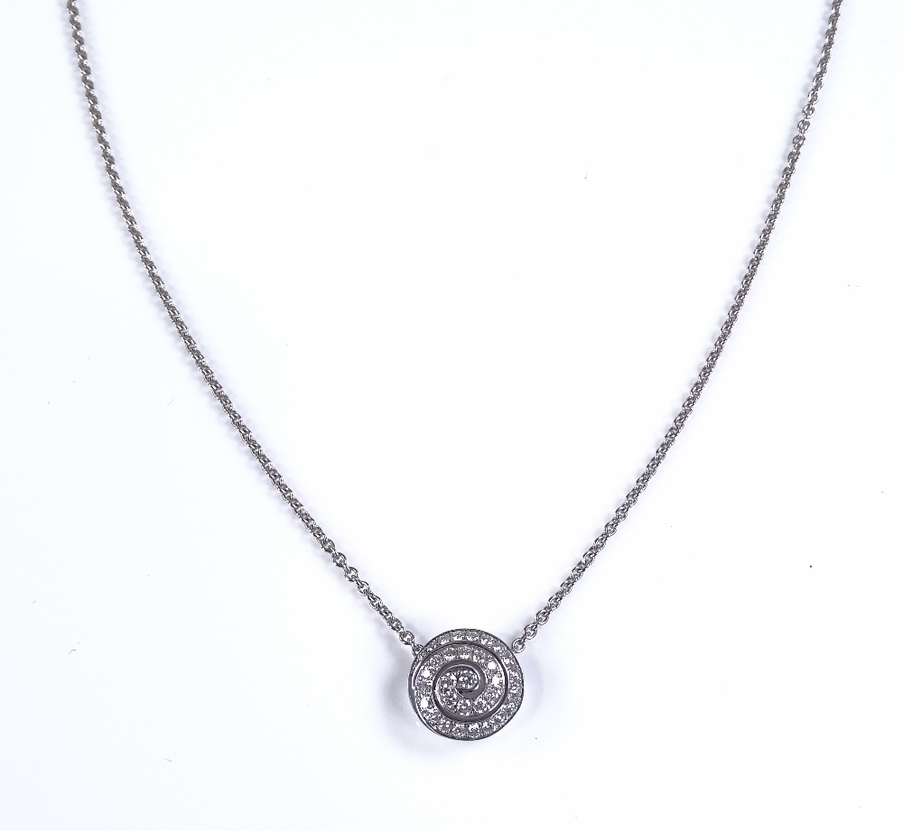 An 18ct white gold diamond swirl pendant, on 18ct