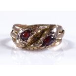 A 9ct gold garnet set double snake head ring, sett