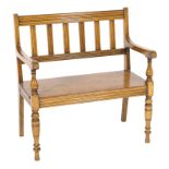 Victorian oak hall settle in the manner of Shoolbred, circa 1900, moulded rail back, open arms,