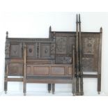 Three carved oak beds, comprising carved oak panelled headboard centred with a lion's mask,