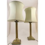 Pair of brass Corinthian column table lamps, with pale green fabric shades,