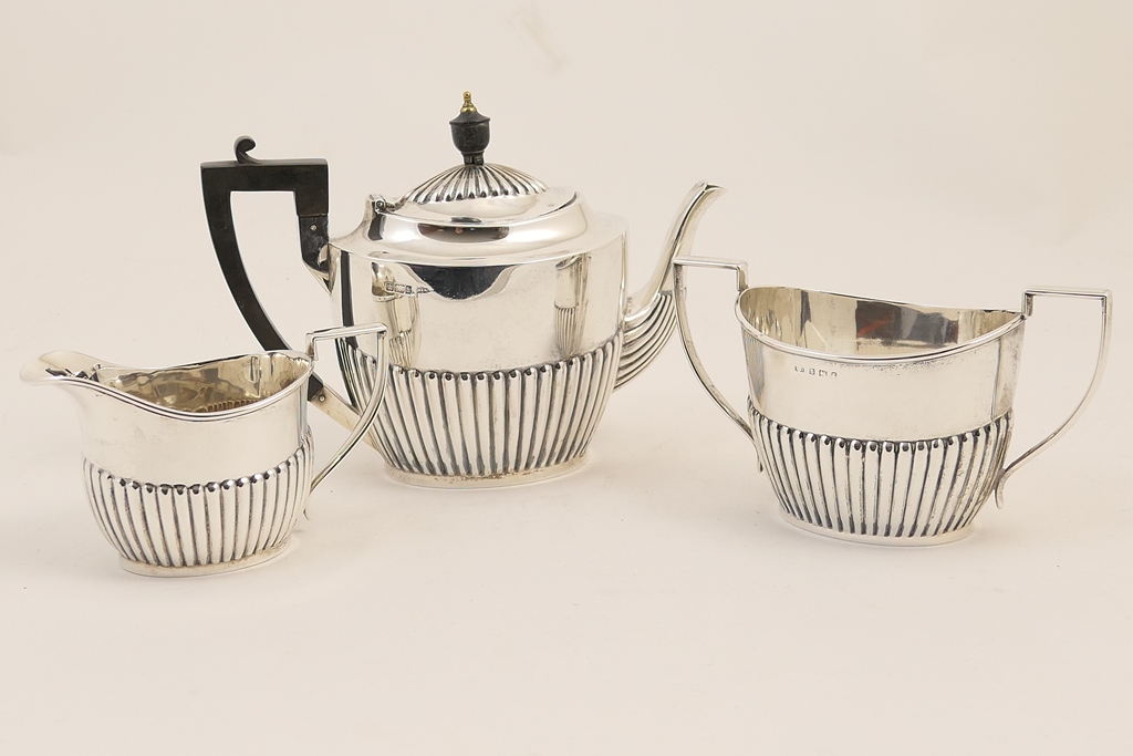 Matched three piece silver tea service, comprising teapot by Walker & Hall, Sheffield 1902,