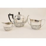 Matched three piece silver tea service, comprising teapot by Walker & Hall, Sheffield 1902,