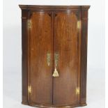 George III oak and mahogany bowfront hanging corner cupboard, circa 1790,