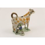 Staffordshire pearlware cow creamer, circa 1810, modelled with a maid seated milking,