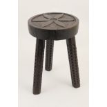 Primitively carved oak dairy stool, probably Welsh, the seat carved with a simplistic flowerhead,