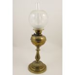 Victorian brass pedestal oil lamp, with a frosted clear glass shade, over a brass tank,