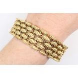 18ct yellow gold bracelet, circa 1972, of broad design with textured elliptical links,