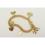 18ct gold curb link charm bracelet, with safety chain, supporting six charms in 9ct and 14ct gold,