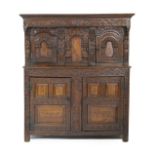 Oak joined press cupboard, late 17th Century with later carved embellishments,