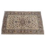 Kashan woollen carpet, ivory field centred with a flowerhead medallion dispersed with palmettes,