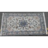 Fine Nain woollen rug, ivory field centred with a blue and ivory scrolled border, size approx.