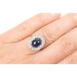 Sapphire and diamond cluster ring, the central cabochon sapphire of approx.
