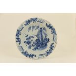 Dutch delft blue and white charger, mid 18th Century, decorated with a giant bamboo, peony and fir,