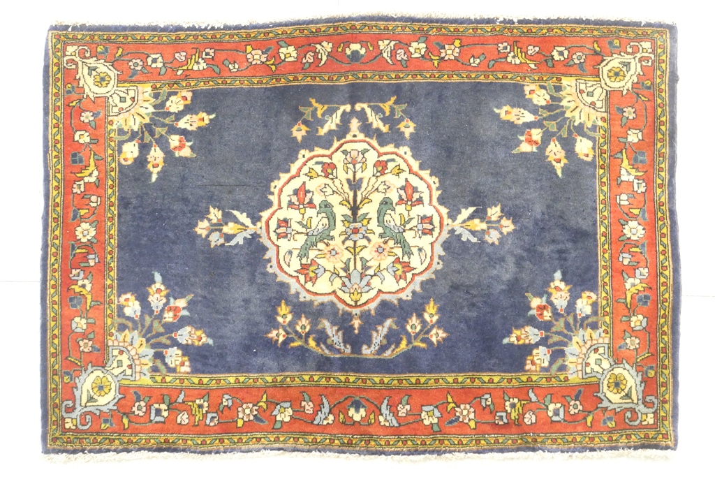 Kerman woollen small rug, blue field with central fawn medallion detailed with birds,
