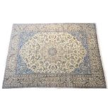 Nain woollen carpet, fawn field dispersed with palmettes and with blue spandrels,