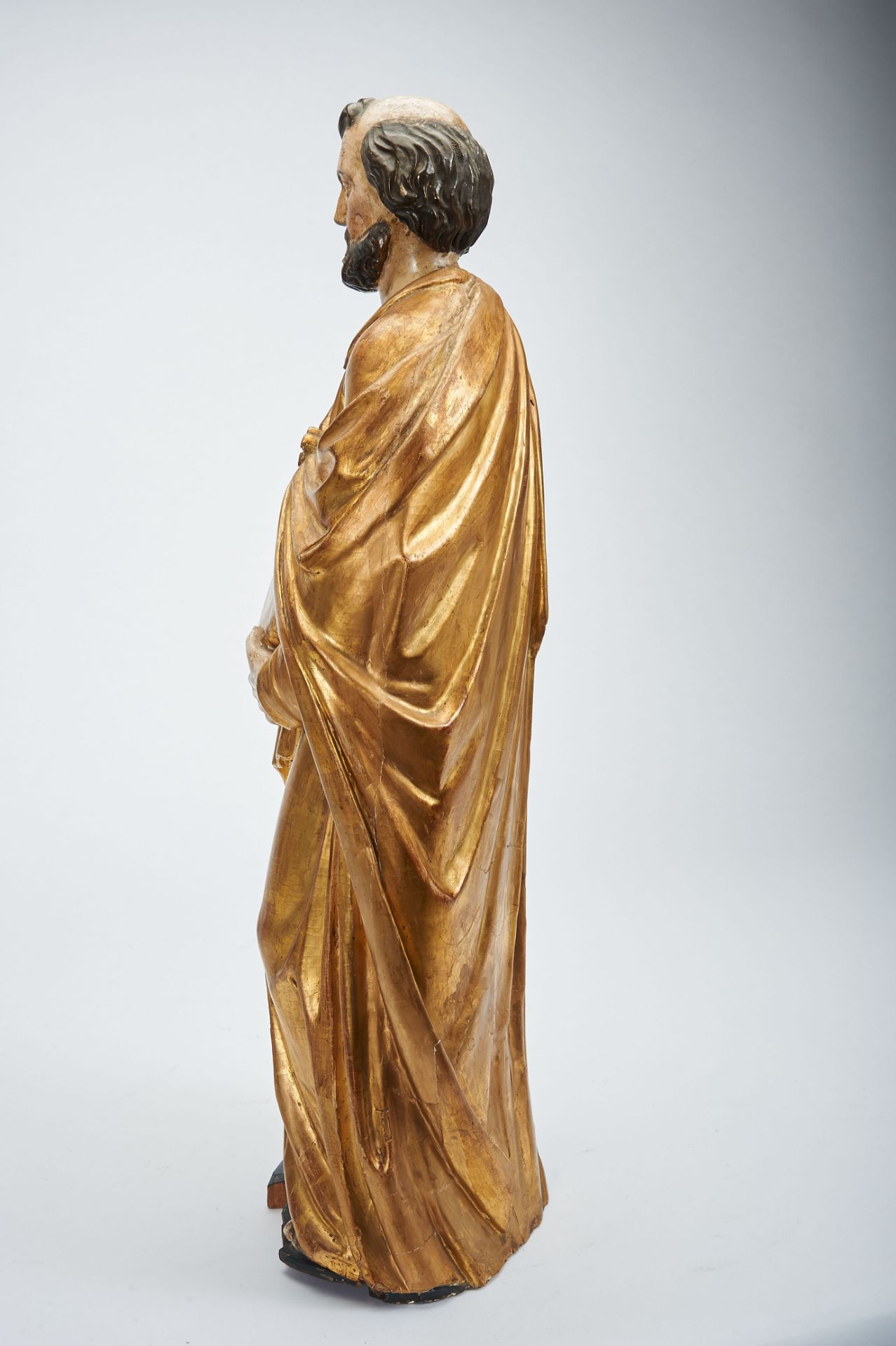 A Saint holding a Book, polychrome and gilt wooden sculpture, French, 18th/19th C., faults,