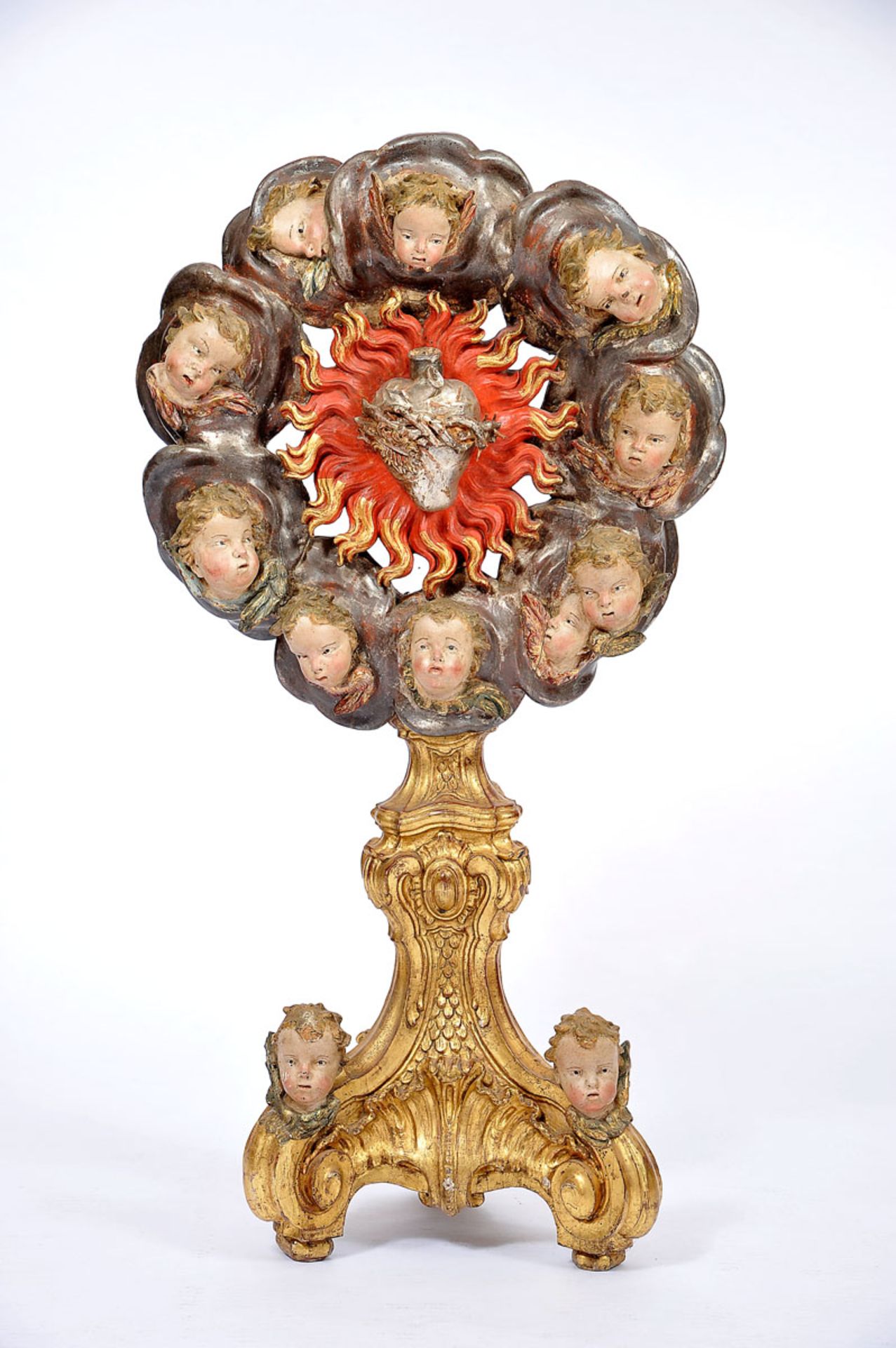 The Sacred Heart surrounded by flames and cherubs, pierced, gilt and silver wooden altarpiece,