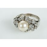 A Ring, 800/1000 gold and 500/1000 platinum, set with one culture pearl (9 mm)and 18 brilliant cut